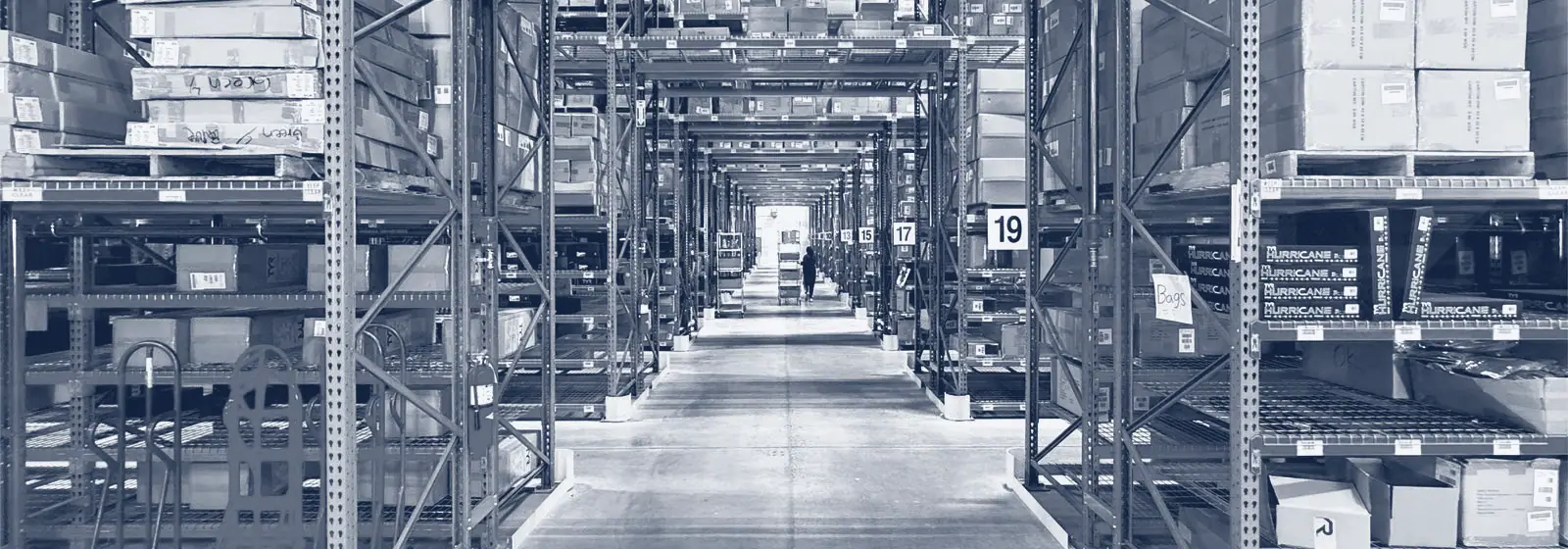 Allée d'entrepôt bordée de rayonnages chargés de cartons